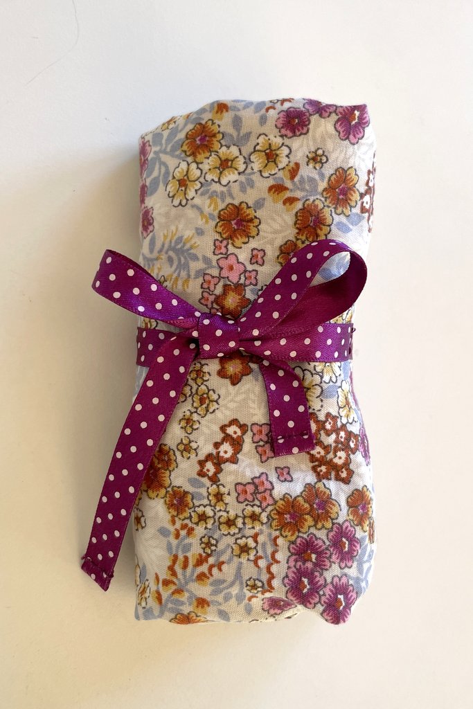 Blommig ihoprullad tygkasse med lilaprickigt knytband, Dressbakery Blommig ihoprullad tygkasse med lilaprickigt knytband, Dressbakery